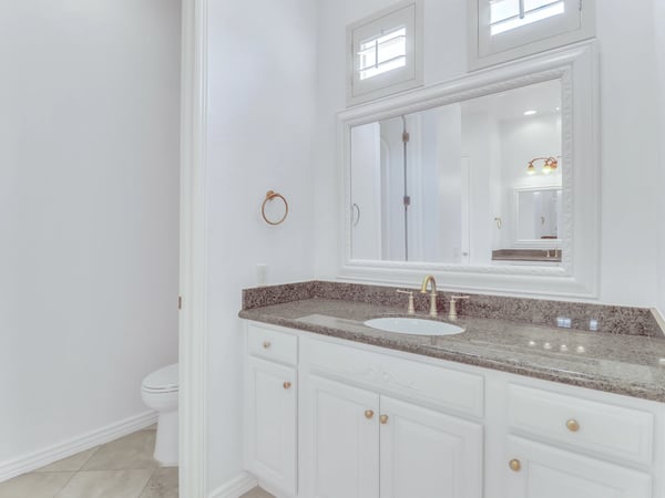 Featuring granite countertops, custom cabinetry, decorative mirror, and premium fixtures, this bathroom combines classic design with everyday functionality in this beautifully maintained Glendale residence.