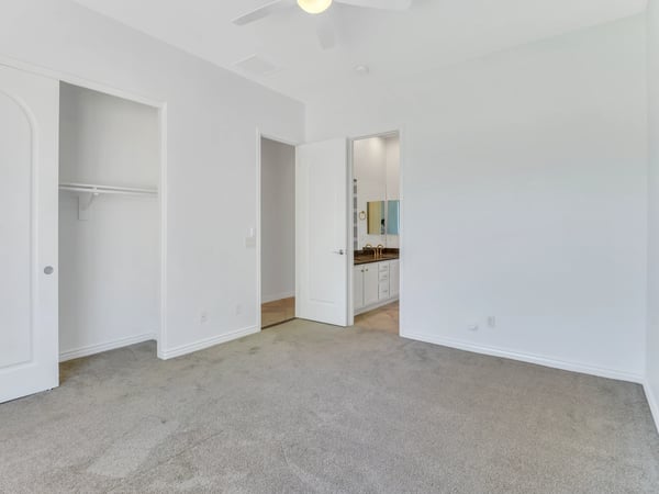 Spacious bedroom offering soft carpeting, neutral d cor, ceiling fan, generous closet storage, and a bright, welcoming atmosphere within this beautifully maintained Glendale property.
