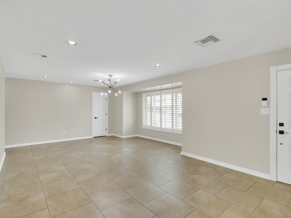 Spacious family room highlighted by plantation shutters, updated finishes, recessed lighting, and an open layout that provides comfortable living space for relaxing or entertaining in this Phoenix rental home.