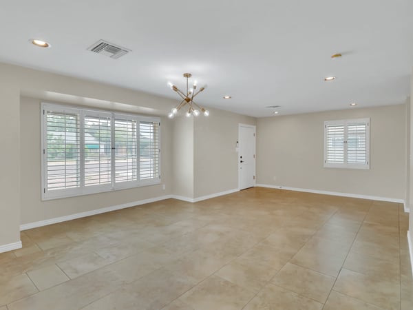 Large open living area filled with natural light, modern finishes, and durable tile flooring offers flexibility for entertaining, dining, or creating a comfortable home office in this Phoenix lease.