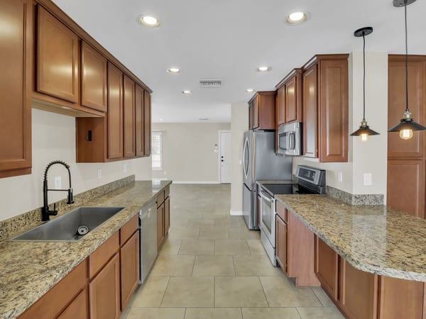 Remodeled kitchen featuring granite countertops, stainless steel appliances, abundant cabinet storage, and recessed lighting. The open design makes this Phoenix rental ideal for both entertaining and everyday living.