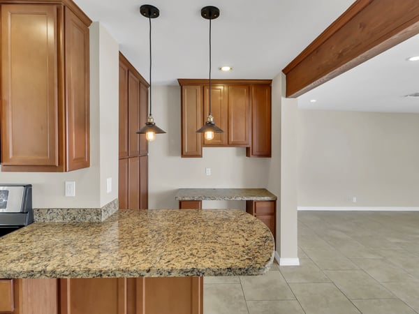 Expansive granite breakfast bar and abundant cabinetry provide generous prep and serving space. This beautifully updated kitchen is a standout feature of this remodeled Phoenix rental.