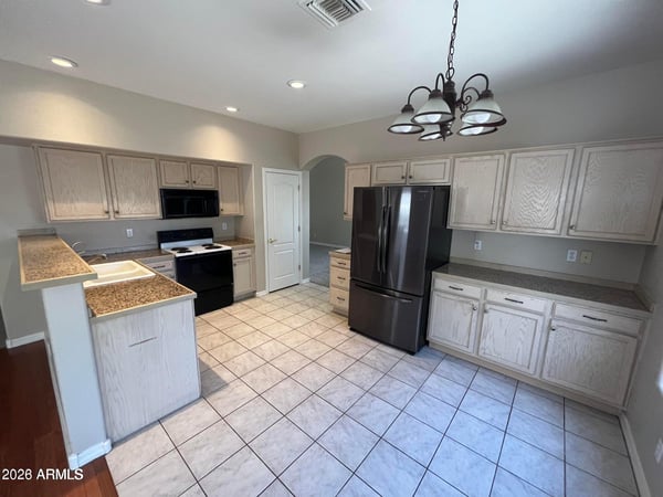 Designed for convenience, this spacious kitchen offers abundant cabinetry, extensive counter space, tile floors, pantry storage, and a bright dining area for casual meals.