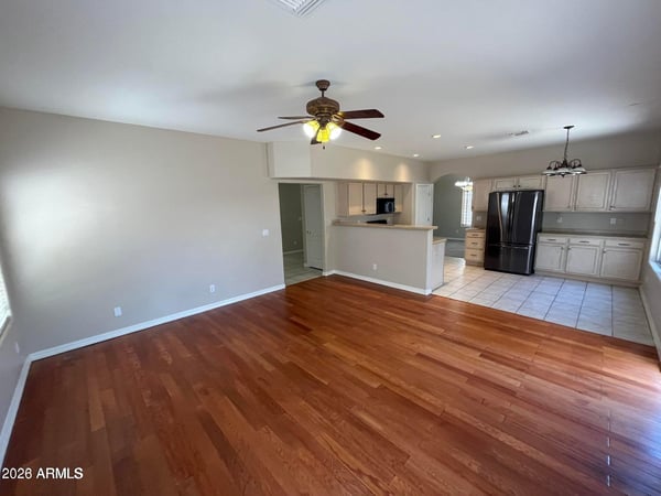 Rich wood flooring, recessed lighting, and an open floor plan make this inviting great room perfect for entertaining, family gatherings, or relaxing at home.