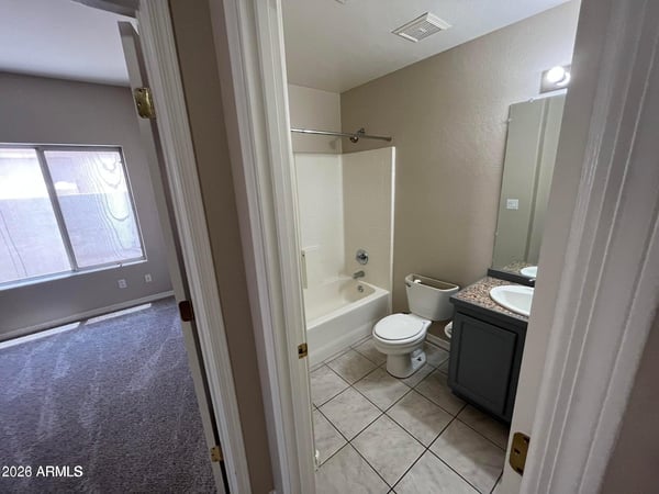 Clean and functional, this full bathroom offers a tub and shower combination, updated vanity, tile flooring, and a practical layout for family and guests.