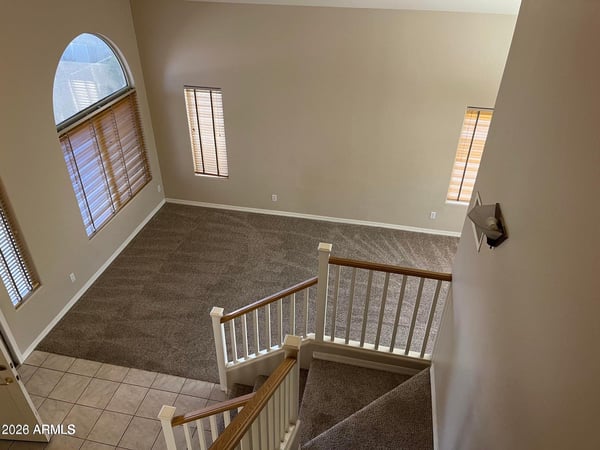 From the upper level, enjoy a striking view of the dramatic foyer featuring vaulted ceilings, expansive windows, and a spacious open-concept design.