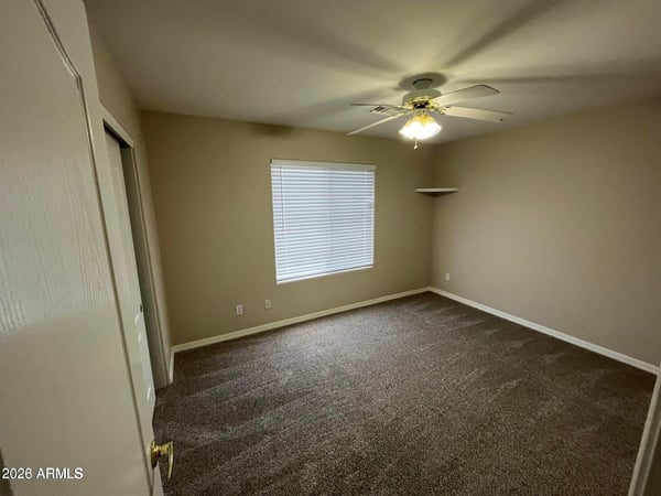 Bright and spacious, this secondary bedroom offers plush carpeting, natural light, a ceiling fan, and flexible space suitable for a variety of living needs.