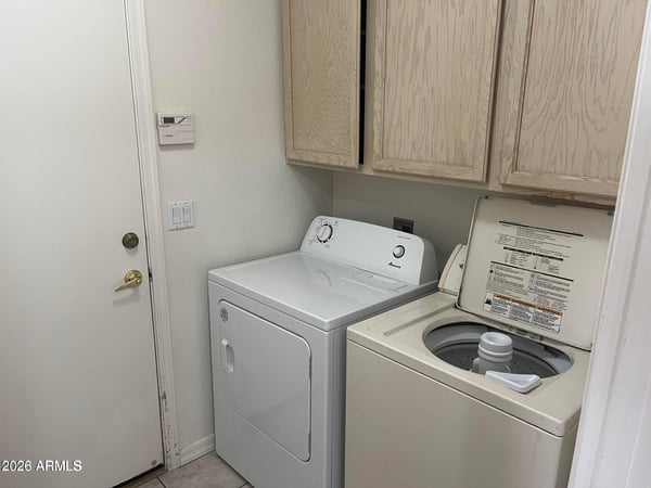 Enjoy the convenience of a dedicated laundry room complete with washer, dryer, built-in cabinetry, and practical storage to simplify daily routines.