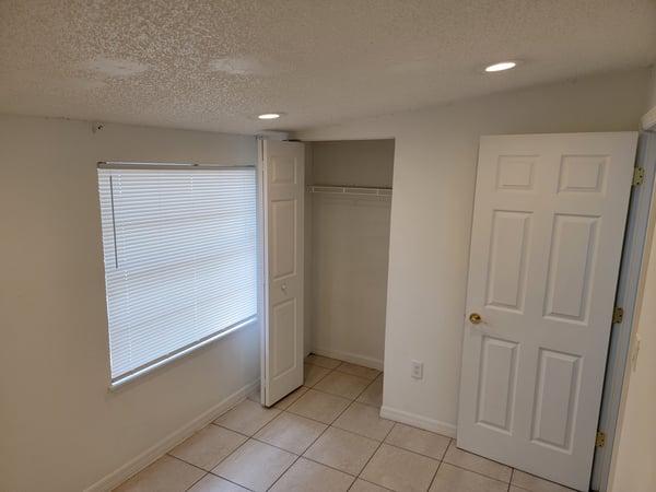 Bright room featuring ample natural light, a spacious closet, and modern tile flooring throughout.