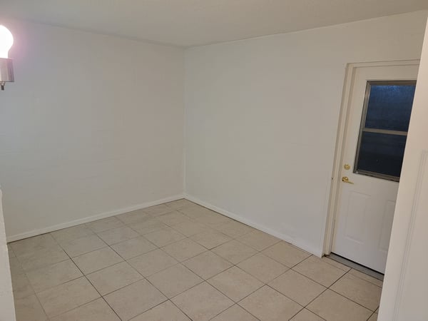 Spacious, versatile room with natural light and easy access to an outdoor entryway. Perfect for customization.