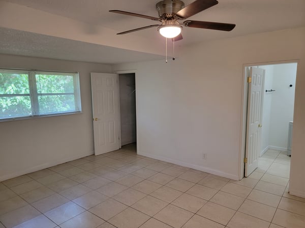 Spacious room featuring ceiling fan, abundant natural light, and easy access to adjoining bathroom and closet.