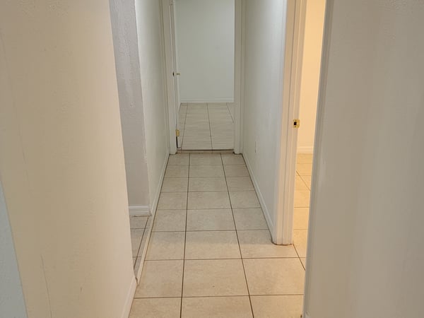 Bright hallway featuring tiled flooring and easy access to adjoining rooms, enhancing the home's functionality.
