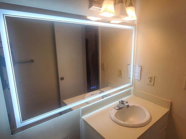 Contemporary bathroom featuring a illuminated mirror and a clean, functional vanity space.
