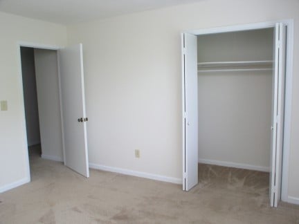 Spacious bedroom with neutral tones and ample closet space, perfect for personal customization and relaxation.