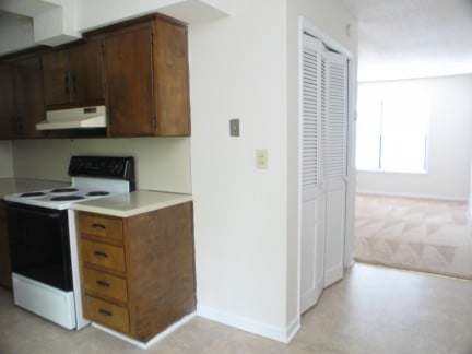 Cozy kitchen with ample storage, leading to an inviting living area filled with natural light.