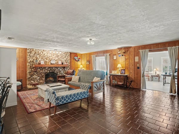 Living Room with large river rock, wood burning fireplace and gorgeous pecky cypress accent walls!