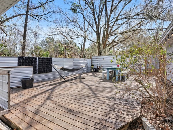 Large deck! This deck was custom built onsite and is really 4 separate decks to allow for easy repairs or board replacement. Set on concrete deck blocks that are strong enough to hold a 5-person spa or pool. Previous owners had both! Wooden walls surrounding the deck offer extensive privacy and are currently covered in metal for an outdoor space that's both kitschy and fun.