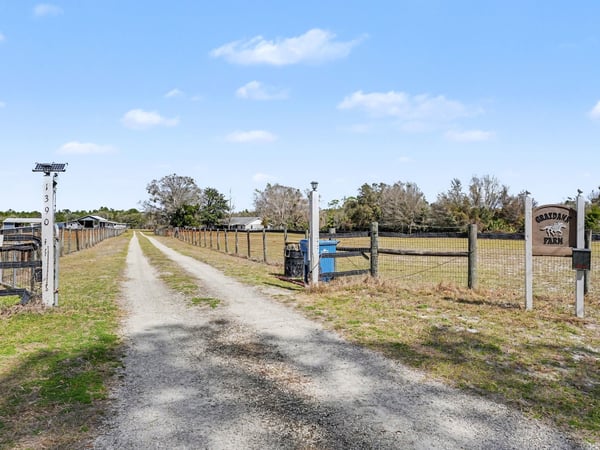 A view of the private driveway from East Ohio Avenue facing north. East Ohio Avenue is a public, county maintained, paved road which easily accommodates trailers, utility vehicles, etc. Bring those toys! Bring those animals! No HOA and county taxes (not city).