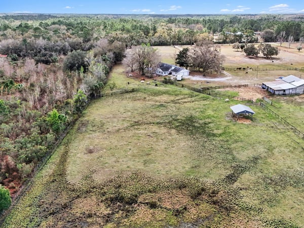 An aerial photo of the pasture and the steel Morton building which can be enclosed to become that shop or RV storage you've dreamed of!