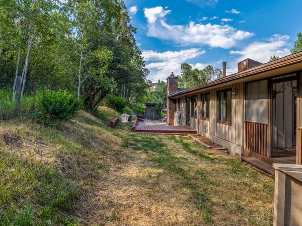 This home features ample outdoor space surrounded by natural greenery, perfect for gatherings and relaxation.