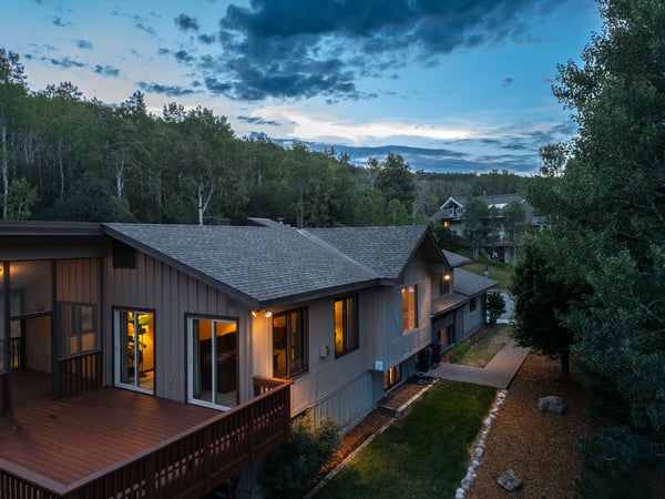 Discover a thoughtfully designed home nestled among tranquil woods, featuring a spacious outdoor deck and inviting landscapes.