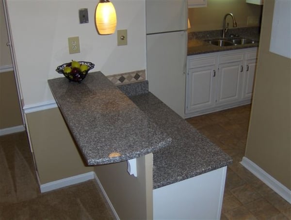 This kitchen features a convenient breakfast bar with granite countertops, perfect for casual dining or entertaining.