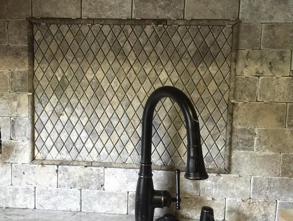 Modern kitchen featuring unique tile accent wall and a sleek, dark-finish faucet for contemporary appeal.