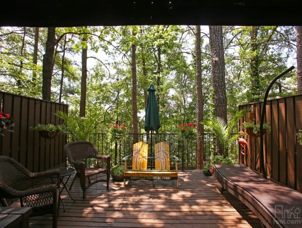 Discover a spacious deck surrounded by lush trees, perfect for relaxation and enjoying nature's beauty.