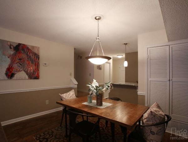 Bright dining area with modern lighting and unique art, perfect for casual meals or entertaining.