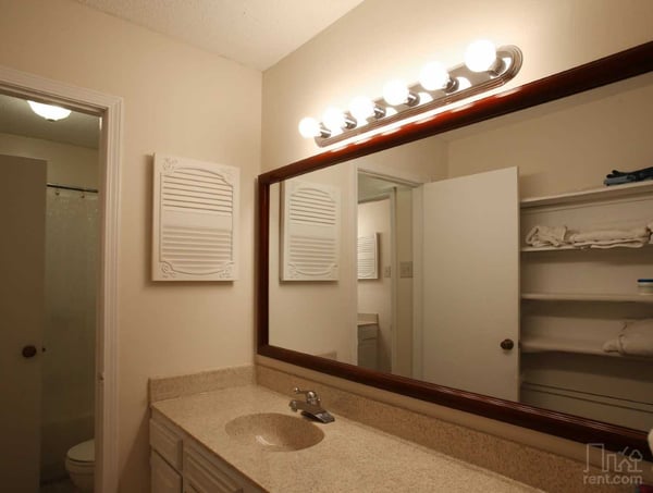 Modern bathroom featuring a spacious countertop, ample storage, and well-lit mirror for daily convenience.