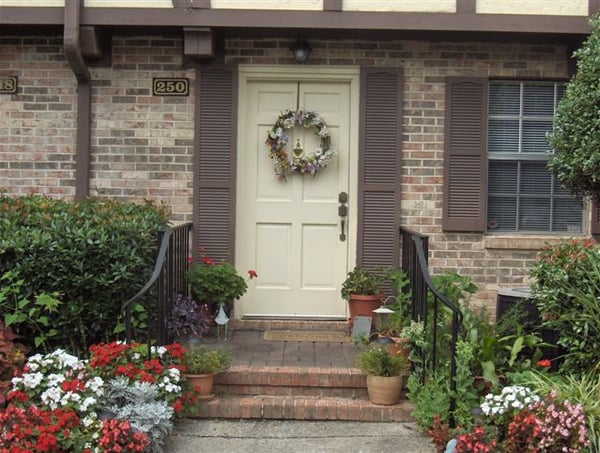 This inviting front entry features vibrant landscaping and a decorative wreath, enhancing its warm appeal.