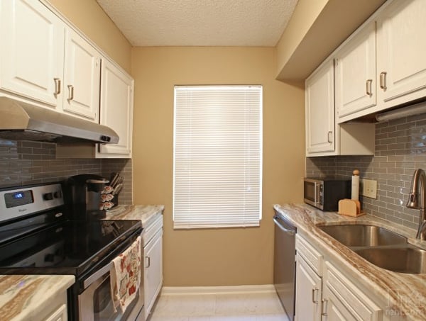 Bright kitchen featuring modern appliances, ample storage, and a cozy layout with natural light.