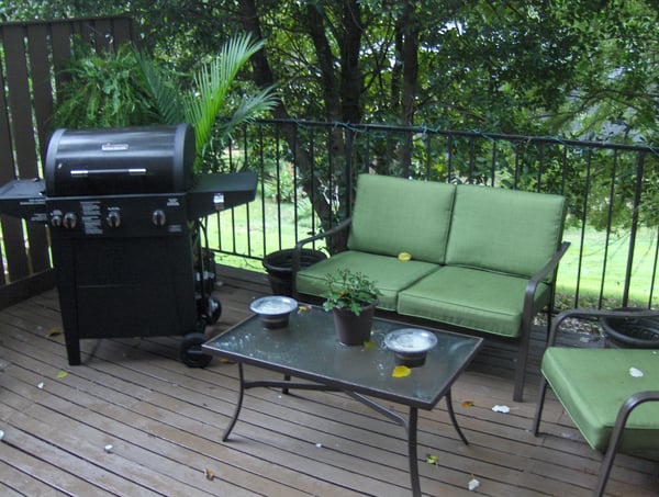 Enjoy outdoor gatherings on this inviting deck featuring a grill and comfortable seating for relaxation.