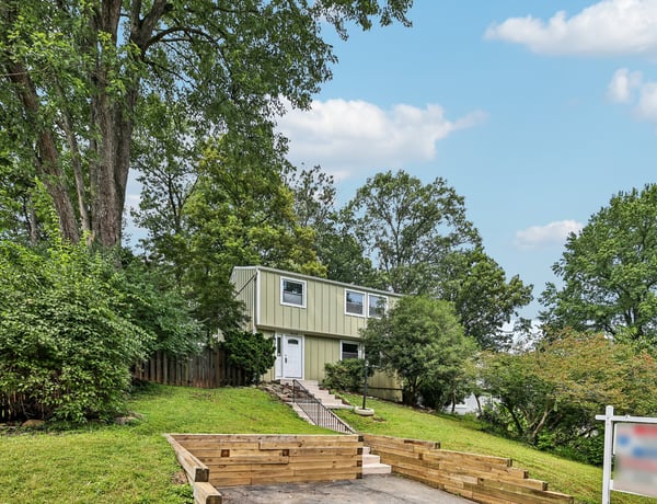 Spacious split-level home surrounded by mature trees, featuring ample outdoor space and convenient access to amenities.