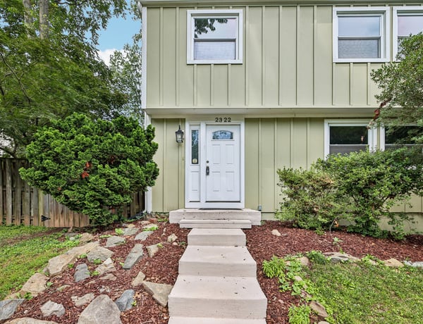 Modern two-story home featuring a welcoming entrance and landscaped yard, perfect for outdoor enjoyment.