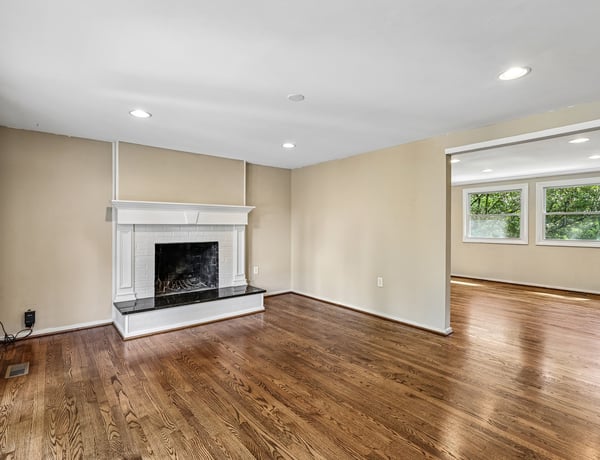 Spacious living area featuring a classic fireplace and large windows, creating a bright and inviting atmosphere.