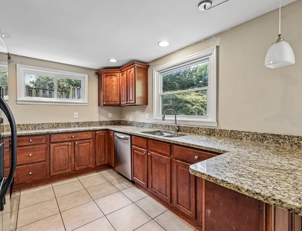 Spacious kitchen featuring rich wood cabinetry, granite countertops, and ample natural light for a warm atmosphere.