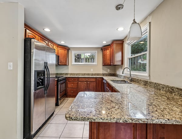 Discover this spacious kitchen featuring ample storage, modern appliances, and inviting granite countertops for culinary enthusiasts.