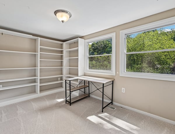 Bright and airy room with built-in shelves and ample natural light, perfect for a home office or study.