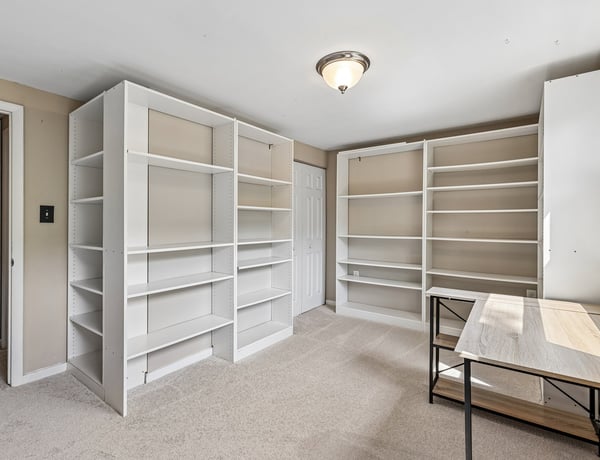 Versatile room featuring built-in shelving, ideal for a home office or creative workspace.