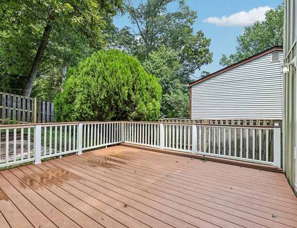 Spacious outdoor deck surrounded by lush greenery, perfect for entertaining or relaxing in your private retreat.