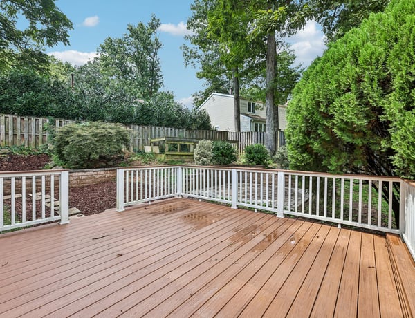 Spacious outdoor deck surrounded by lush greenery, perfect for hosting gatherings or enjoying quiet moments.
