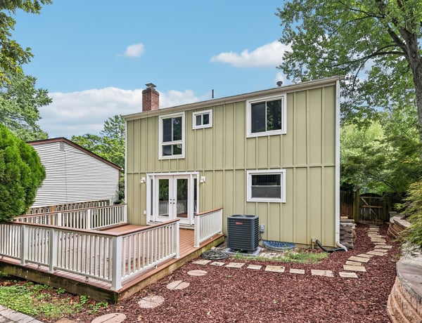 This inviting two-story home features a spacious deck and landscaped yard, perfect for outdoor gatherings.