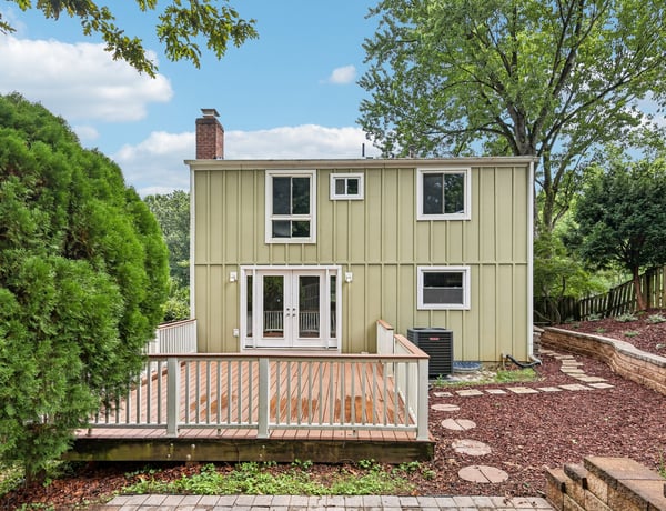 Discover this inviting home featuring a spacious deck, surrounded by lush greenery and easy outdoor access.