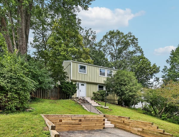 This unique split-level home offers spacious living areas surrounded by lush greenery and a private yard.