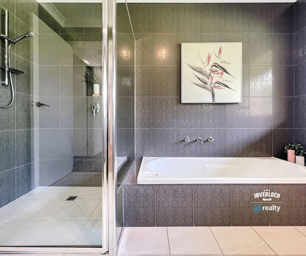 Spacious bathroom featuring a double vanity, modern shower, and relaxing bathtub for ultimate comfort.