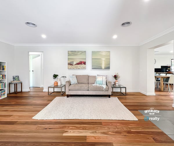 Bright and spacious living area featuring warm wooden floors, modern artwork, and an inviting atmosphere.