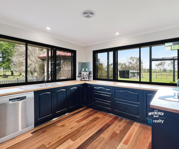 Modern kitchen with panoramic windows, featuring sleek cabinetry and scenic views of the surrounding landscape.