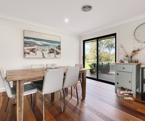 Bright dining area featuring large windows, showcasing views of the outdoors and modern design elements.