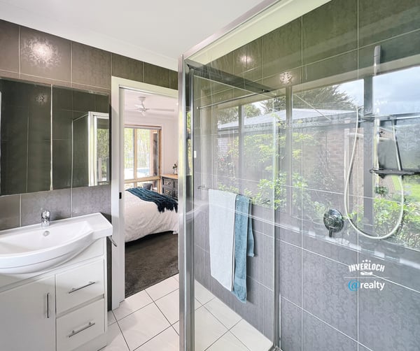 Modern bathroom featuring a spacious shower, sleek fixtures, and a seamless view of the landscaped garden.